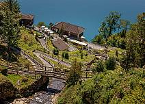 Blick hinab zur Bushaltestelle Beatushöhlen der STI und dem Thunersee. (bei Klick vergrösserte Ansicht Bild)