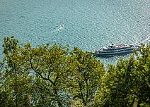 Über die Wipfel der Bäume nimmt der Thunersee das Blickfeld ein. Auf dem See fährt ein Kursschiff der BLS. (bei Klick vergrösserte Ansicht Bild)