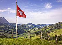 Im Wind flatternde Schweizer Fahne und ein atemberaubender Ausblick auf das Emmental. (bei Klick vergrösserte Ansicht Bild)